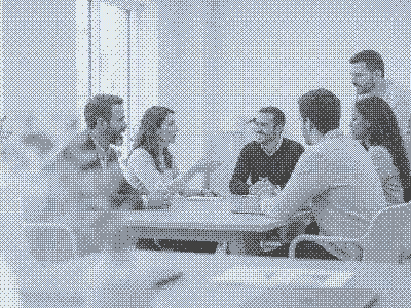 Six people sitting around a table in conversation